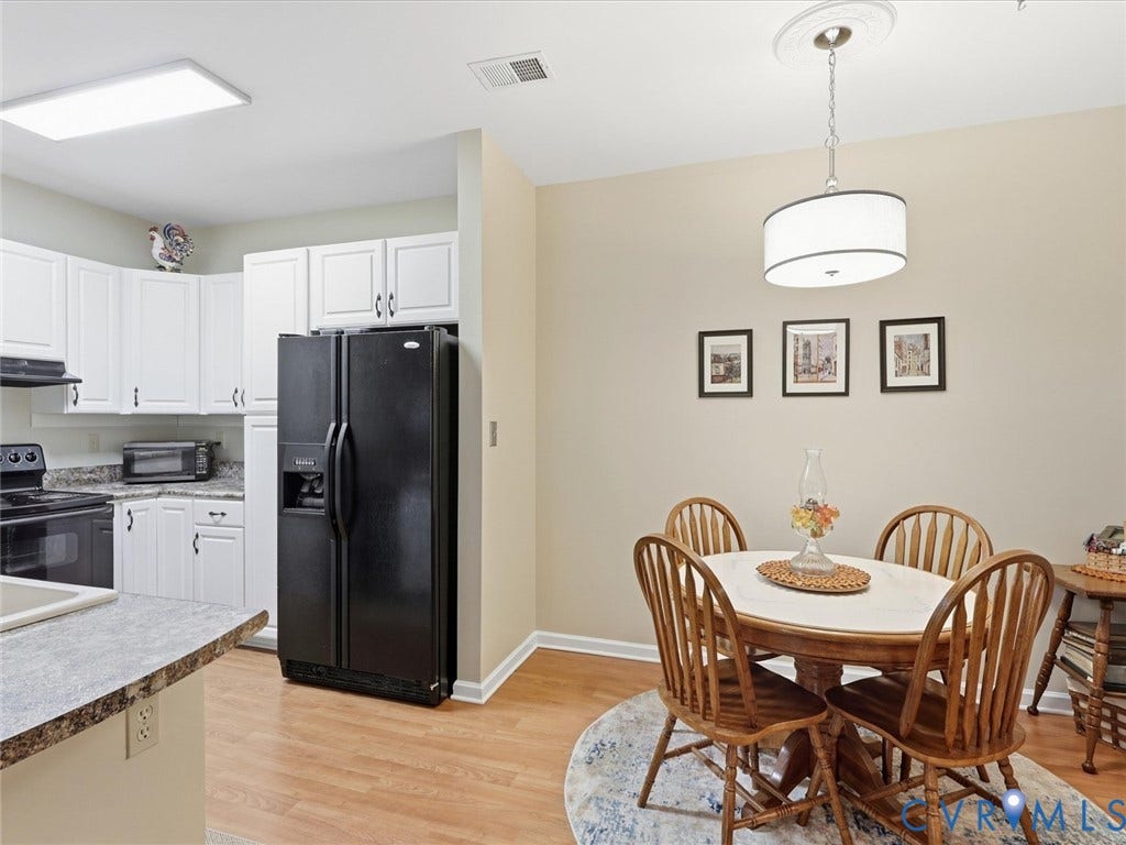 Kitchen featuring white cabinetry, a black side-by-side refrigerator, and a built-in electric range