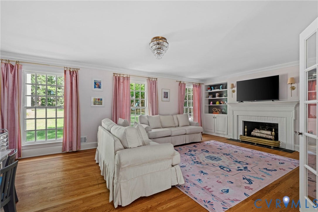 Hardwood flooring, multiple grid-pattern windows, built-in shelving, fireplace, and French doors