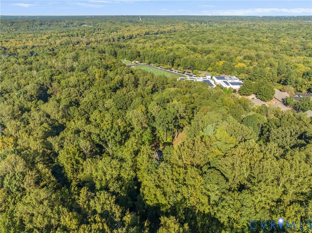 Expansive forested landscape surrounding a distant building complex