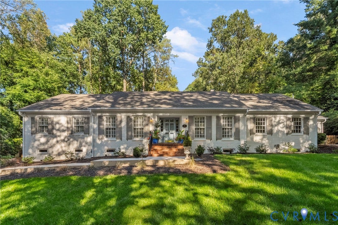 White painted brick exterior with gray shutters, a light blue front door, and a gray shingled roof