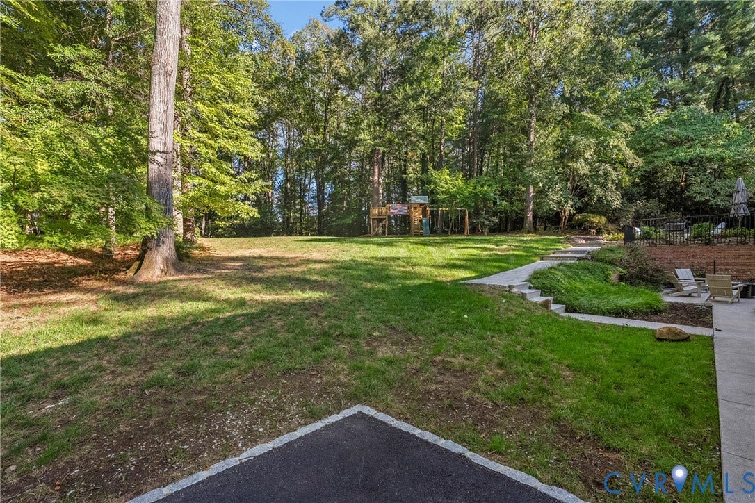 Expansive lawn with mature trees and a paved walkway
