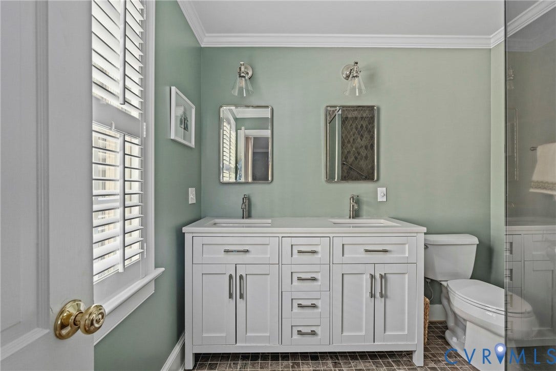 Dual vanity with undermount sinks and brushed nickel hardware, white stone-finish countertop, plantation shutters, and crown molding