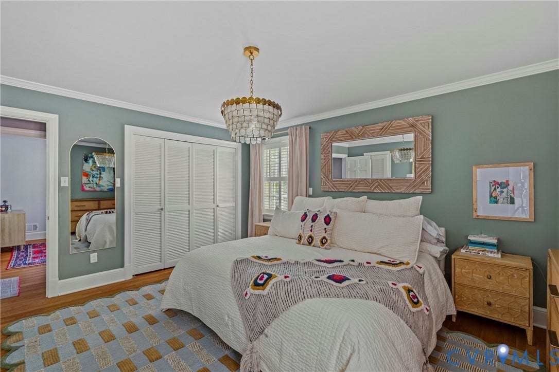 Hardwood flooring, crown molding, double louvered closet doors, and an elegant chandelier