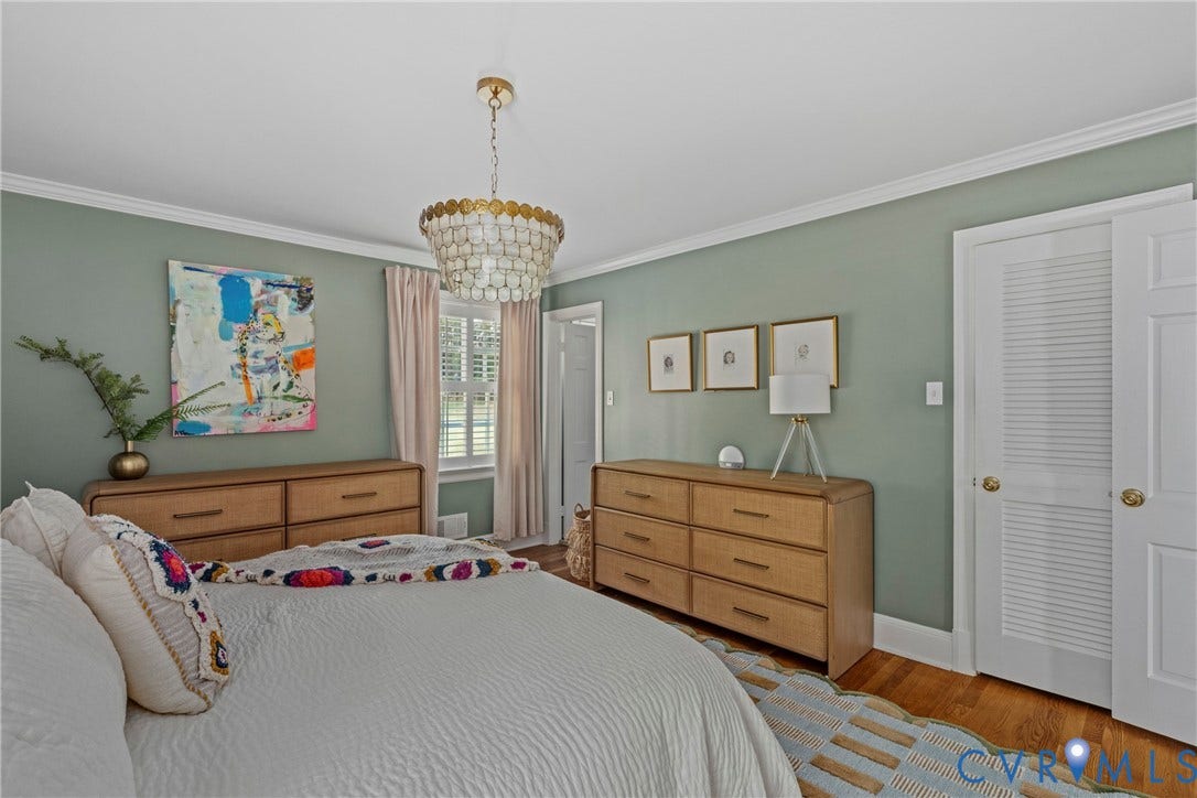 Hardwood flooring, crown molding, white trim, and a decorative ceiling light fixture