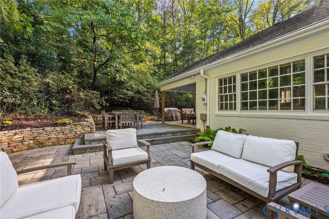 Expansive multi-level stone patio with a stone retaining wall