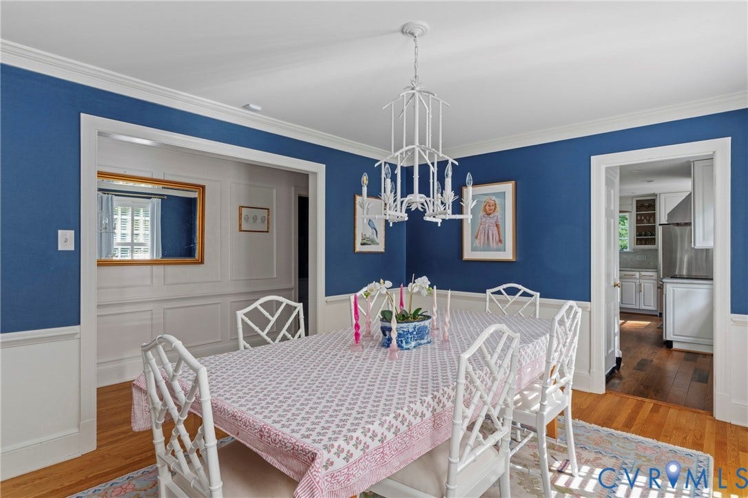 Hardwood flooring, crown molding, chair rail molding, and a white chandelier with candelabra bulbs