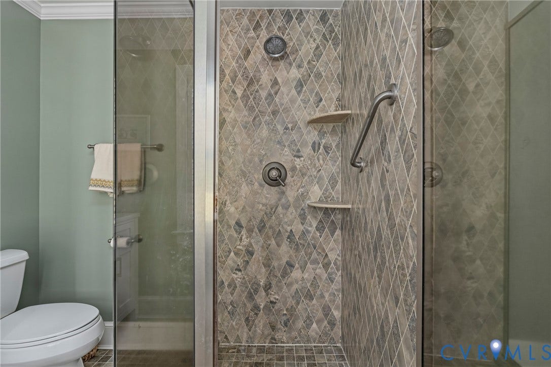 Shower with diamond-patterned tile, multiple shower heads, and built-in shelving