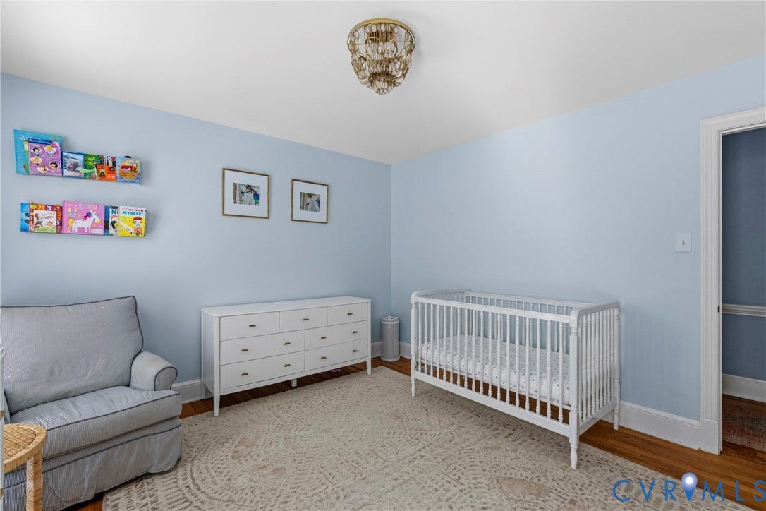 Hardwood flooring, crown molding, and a built-in ceiling light fixture