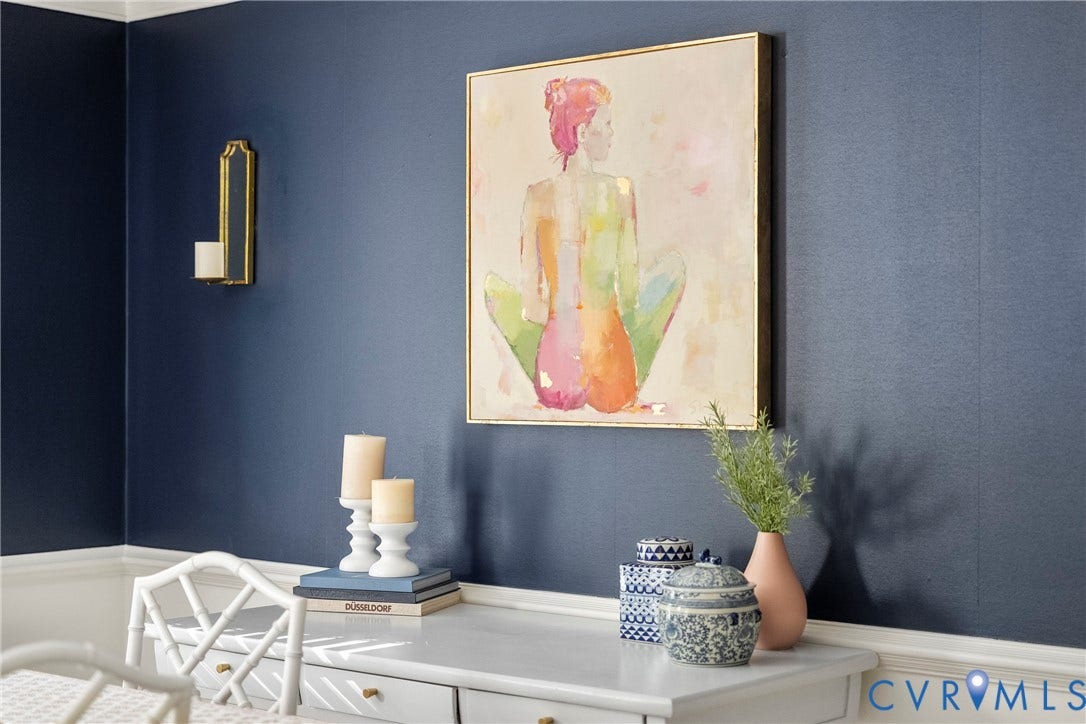 Accent wall with textured blue covering, white baseboard trim, and a built-in white desk with drawer pulls