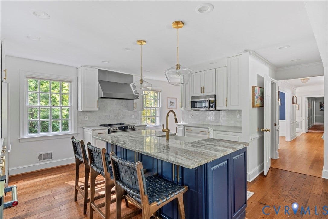 Kitchen featuring a blue island with a stone countertop, white cabinetry with gold-tone hardware, a stainless steel range with a ventilation hood, and wood-finish flooring