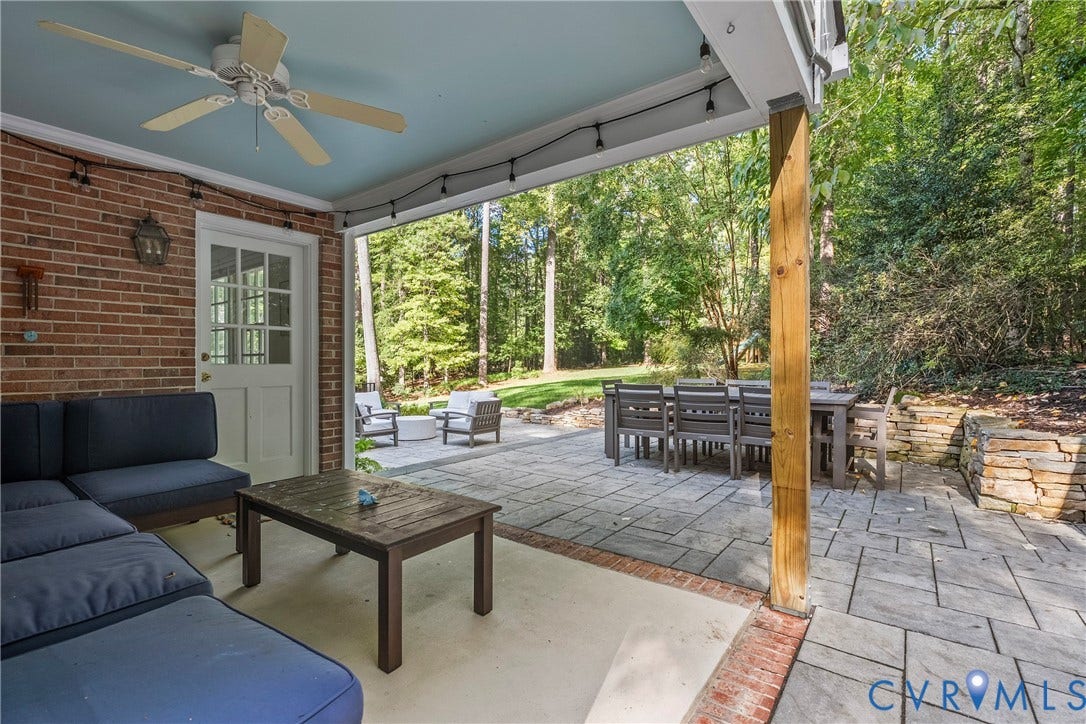 Covered patio with brick wall and ceiling fan