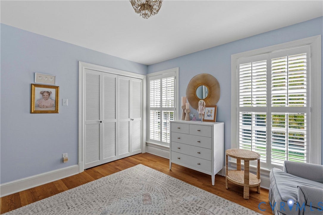 Hardwood flooring, louvered bi-fold closet doors, and plantation shutters