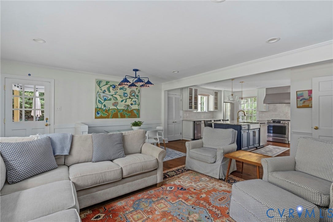 Expansive living area with recessed lighting, crown molding, and a paneled door with glass inserts