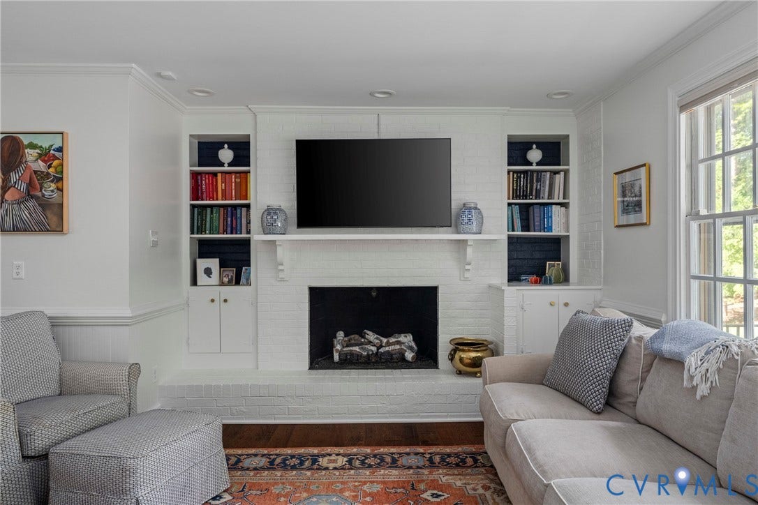 Built-in shelving flanking a brick fireplace with a mantel