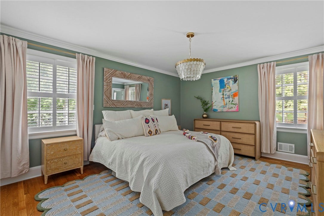 Hardwood flooring, crown molding, double windows with plantation shutters, and a shell-effect chandelier