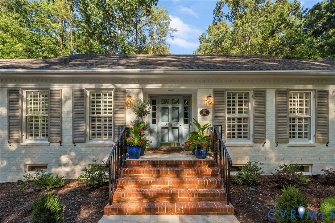 White painted brick exterior with a light blue double entry door