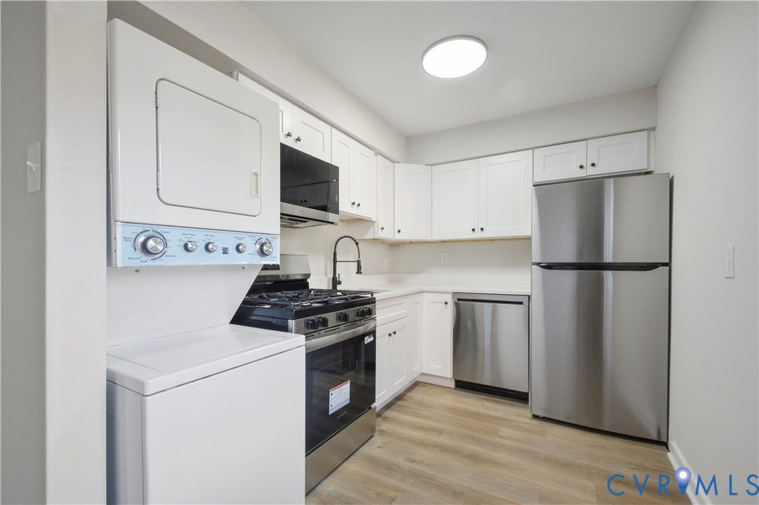 Kitchen featuring white cabinetry, white countertops, stainless steel appliances, and wood-finish flooring