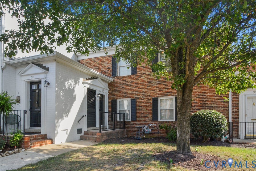 Brick and white painted brick exterior with black shutters and front doors