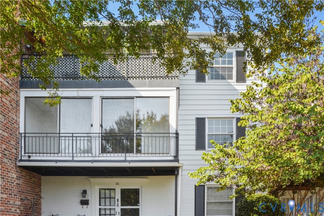 Brick and siding exterior with a second-story balcony featuring a black metal railing