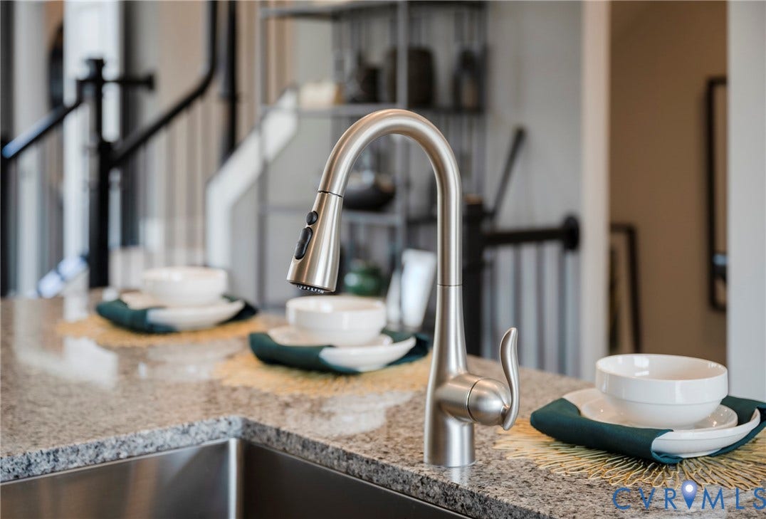 Stainless steel pull-down faucet, undermount stainless steel sink, and speckled countertop