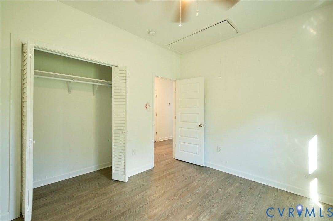 2421 Buena Vista Boulevard, Chester, VA 23831 Wood-finish flooring, white paneled door, louvered bi-fold closet doors, ceiling fan, and attic access panel