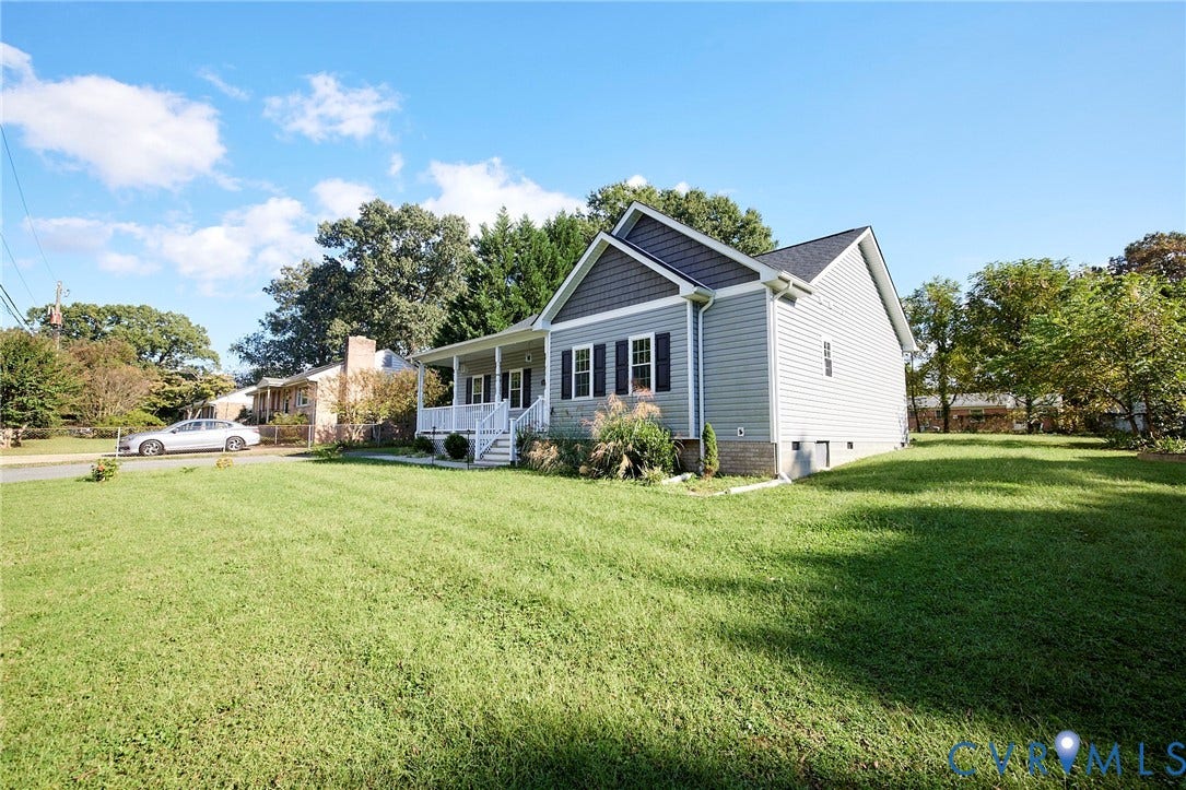 2421 Buena Vista Boulevard, Chester, VA 23831 Light-colored siding exterior with dark grey gables, a covered front porch with white railings, and a side yard with a grass lawn
