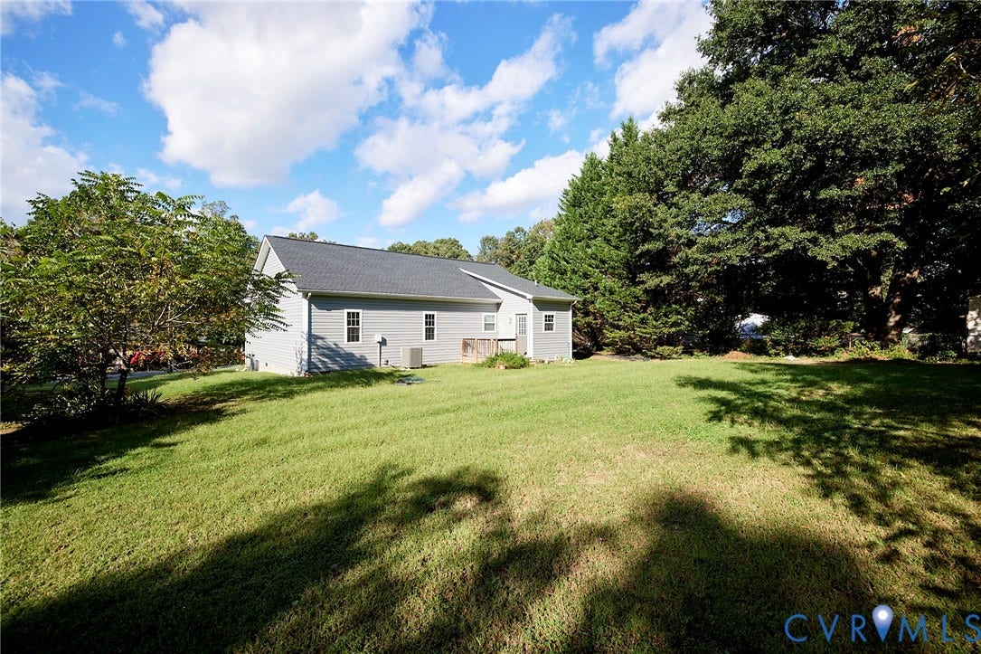 2421 Buena Vista Boulevard, Chester, VA 23831 Expansive rear lawn with mature trees and a gray siding exterior