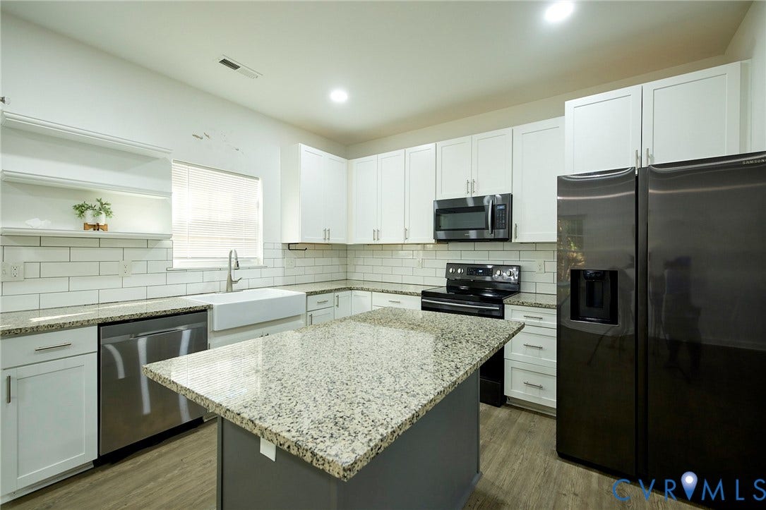 2421 Buena Vista Boulevard, Chester, VA 23831 Spacious kitchen featuring white cabinetry, light-toned granite countertops, a large center island, and stainless steel appliances