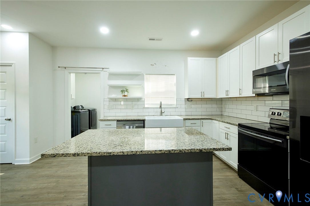 2421 Buena Vista Boulevard, Chester, VA 23831 Kitchen featuring a center island with a speckled countertop, white cabinetry, subway tile backsplash, and stainless steel appliances