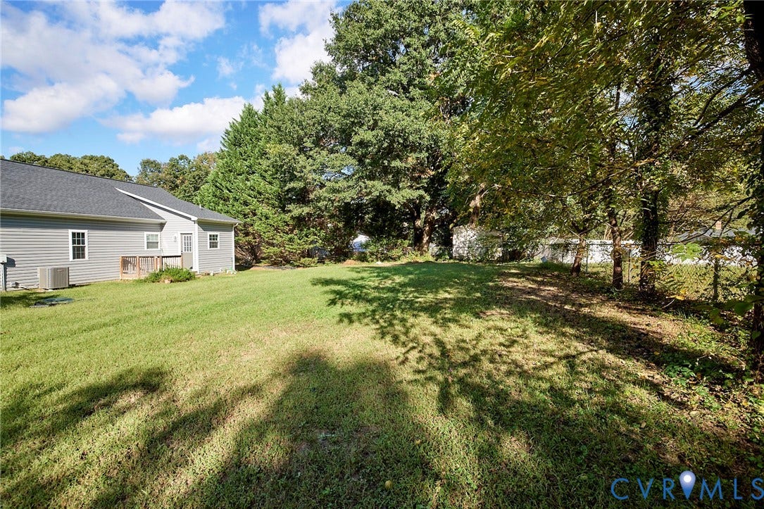 2421 Buena Vista Boulevard, Chester, VA 23831 Expansive backyard featuring a manicured lawn, established trees, and a rear deck