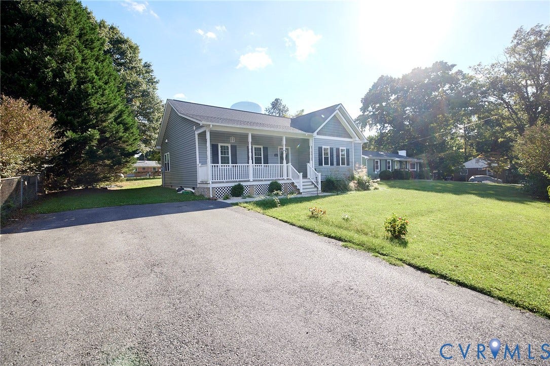 2421 Buena Vista Boulevard, Chester, VA 23831 Classic ranch-style home featuring a welcoming front porch with white columns and railings, situated on an expansive manicured lawn bordered by mature landscaping
