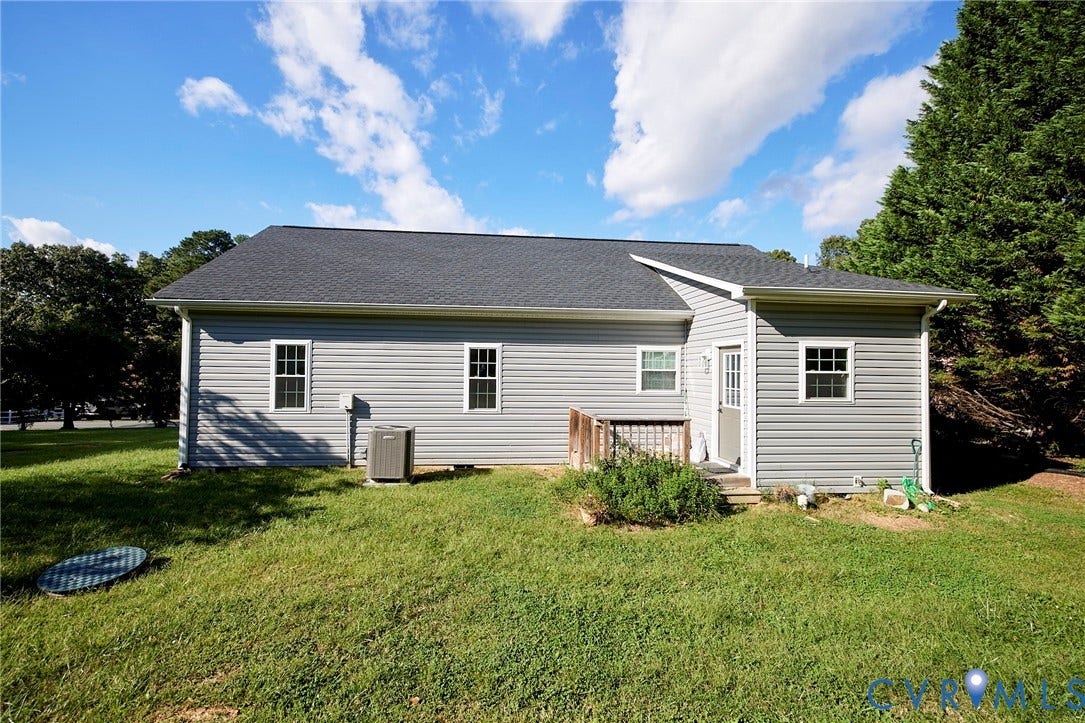 2421 Buena Vista Boulevard, Chester, VA 23831 Gray horizontal siding exterior with a dark shingle roof, white trim windows, and an exterior door with a wood railing