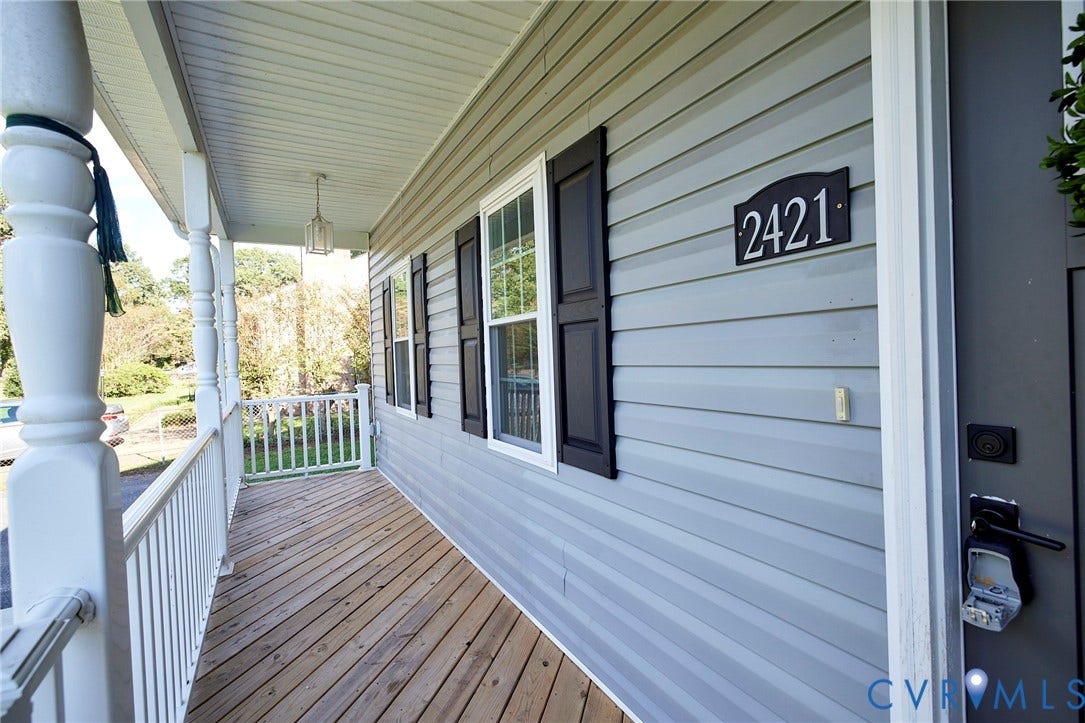 2421 Buena Vista Boulevard, Chester, VA 23831 Inviting front porch featuring wood-finish decking, white railings, light gray siding, and decorative black shutters