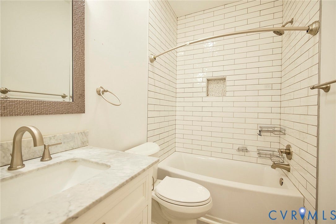 2421 Buena Vista Boulevard, Chester, VA 23831 White subway tile surround with a built-in shower niche, brushed nickel fixtures, and a curved shower rod