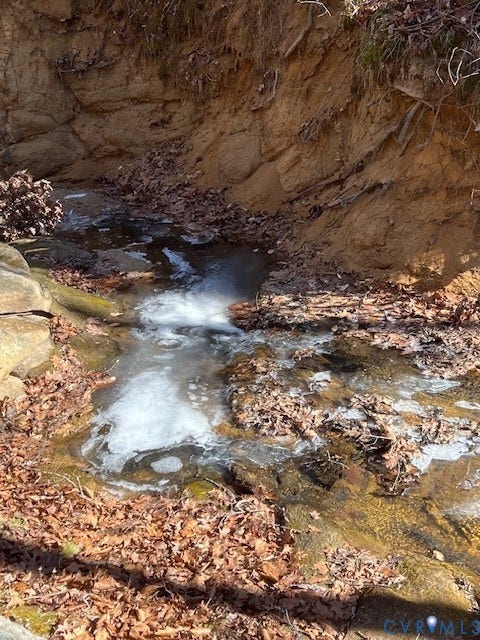 Natural stream feature with rock-lined banks and surrounding foliage
