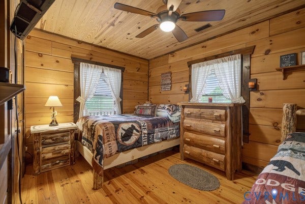 2nd bedroom Wood walls and ceiling, wood-finish flooring, ceiling fan, and window with blinds