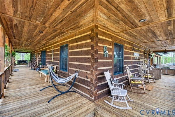 Expansive wrap-around porch featuring wood plank decking and a wood plank ceiling