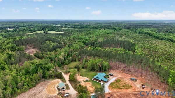 Expansive treed landscape with a single-story dwelling featuring a green roof