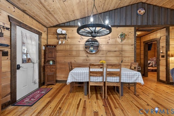 Wood walls and ceiling, wood-finish flooring, and a wagon wheel-style chandelier