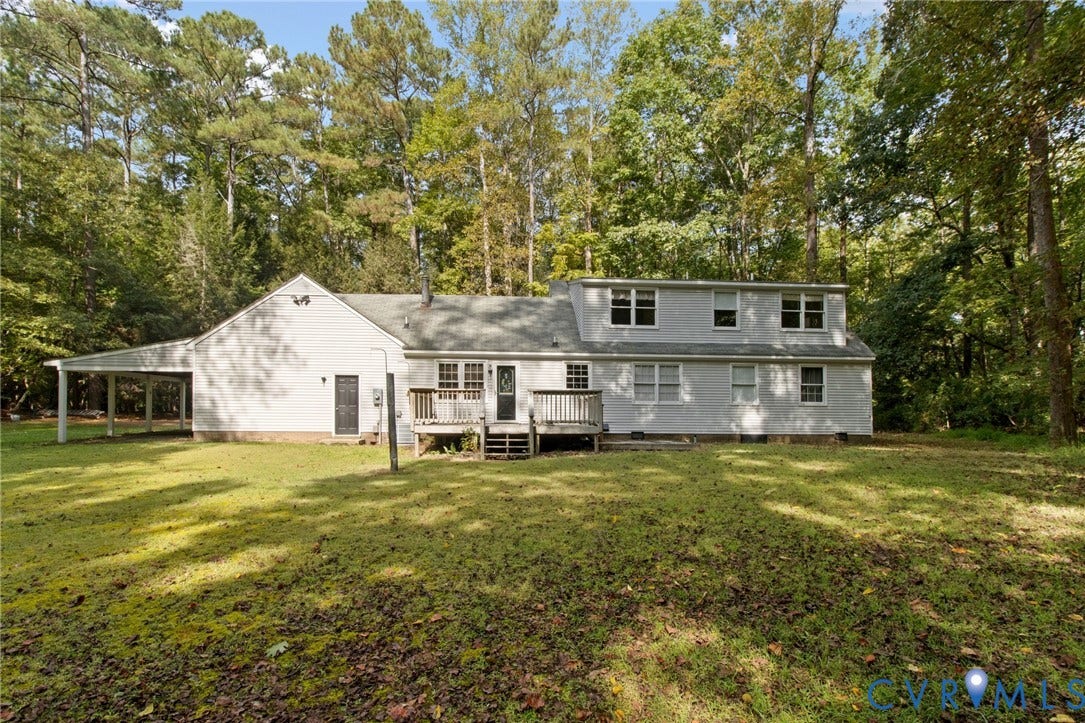 7847 Beaver Drive, All Others Area 20, Gloucester, VA 23061 Spacious backyard with a wood deck, carport, and mature trees providing a natural backdrop