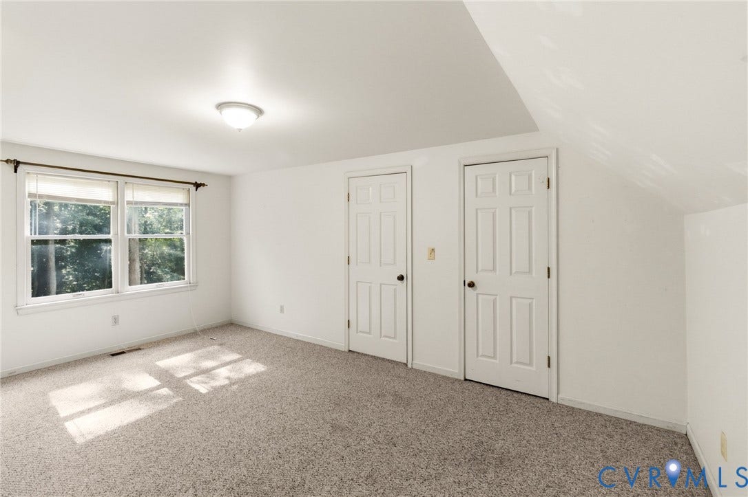 7847 Beaver Drive, All Others Area 20, Gloucester, VA 23061 Carpeted room featuring multiple windows, two paneled doors, and a ceiling-mounted light fixture