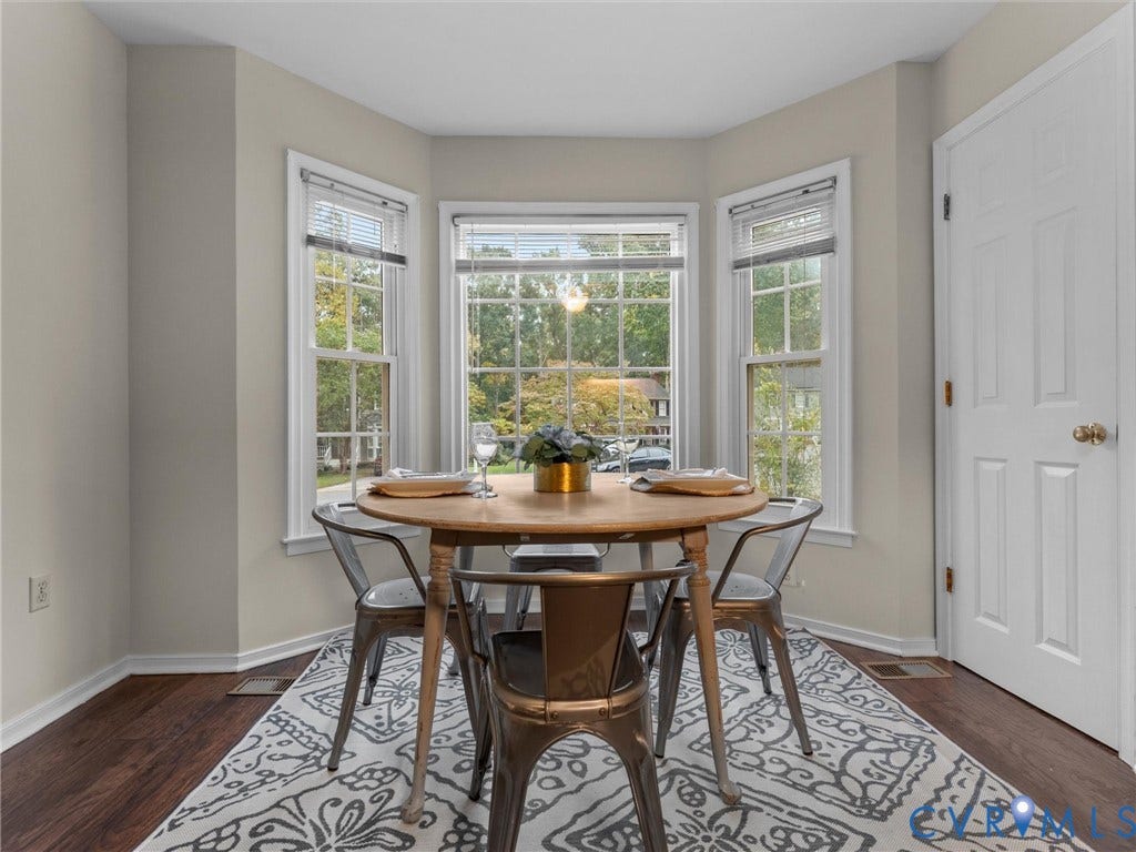Bay window featuring three multi-pane windows and wood-finish flooring