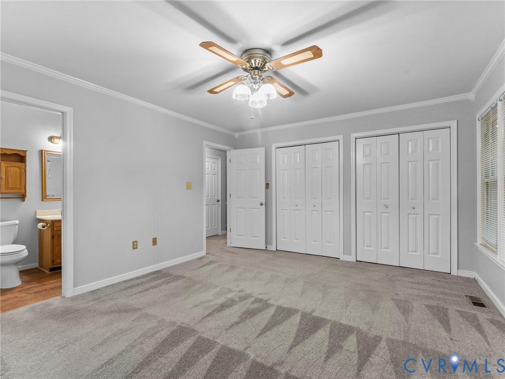 Neutral wall tones, wall-to-wall carpeting, ceiling fan with integrated lighting, dual bifold closet doors, and multi-panel interior doors