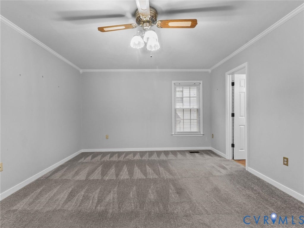 Room featuring neutral wall tones, wall-to-wall carpeting, crown molding, a multi-pane window, and a ceiling fan with integrated lighting