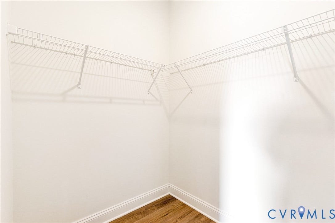 Wire shelving system, light-toned walls, and wood-finish flooring