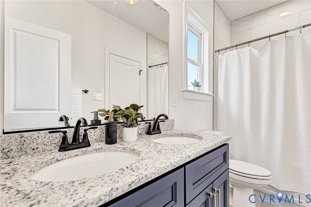 Dual vanity with granite countertop, undermount sinks, and matte black fixtures