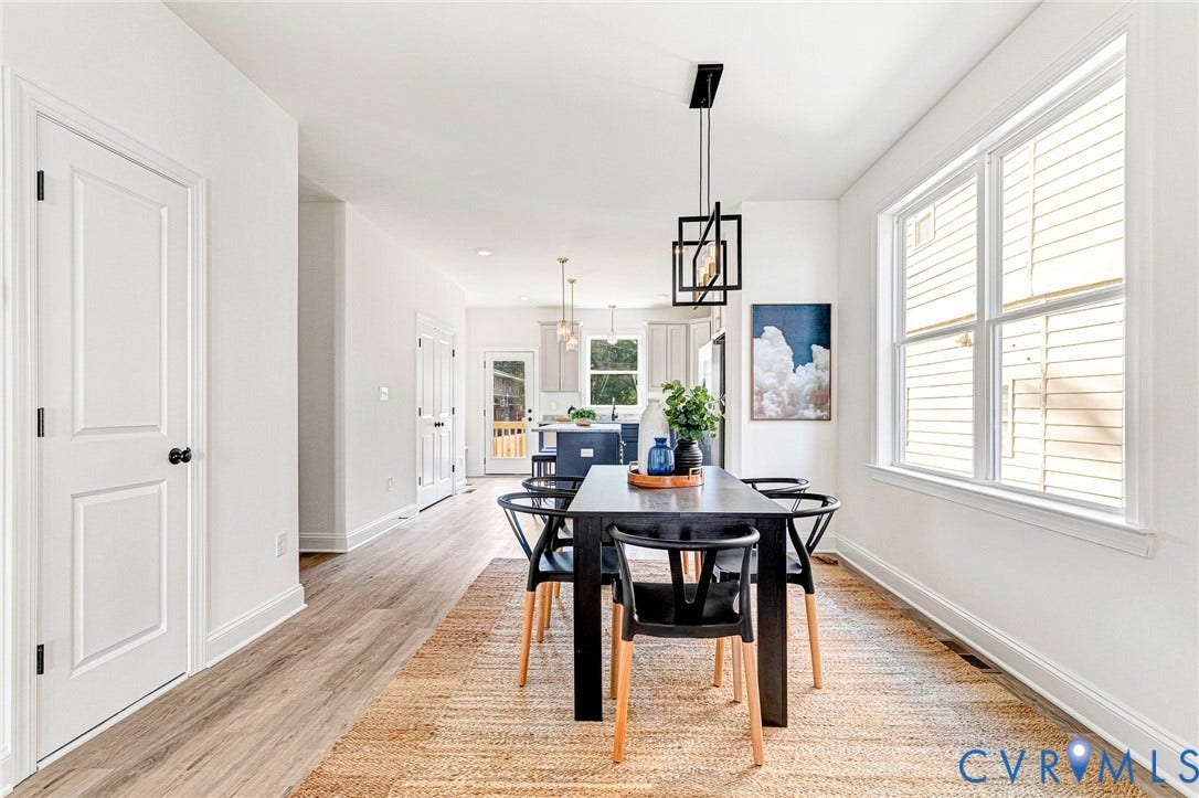 Wood-finish flooring, white paneled doors, and a decorative pendant light fixture