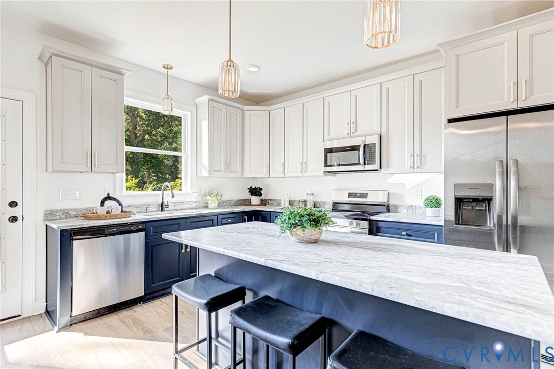 Two-tone cabinetry with stainless steel appliances, a center island, and wood-finish flooring