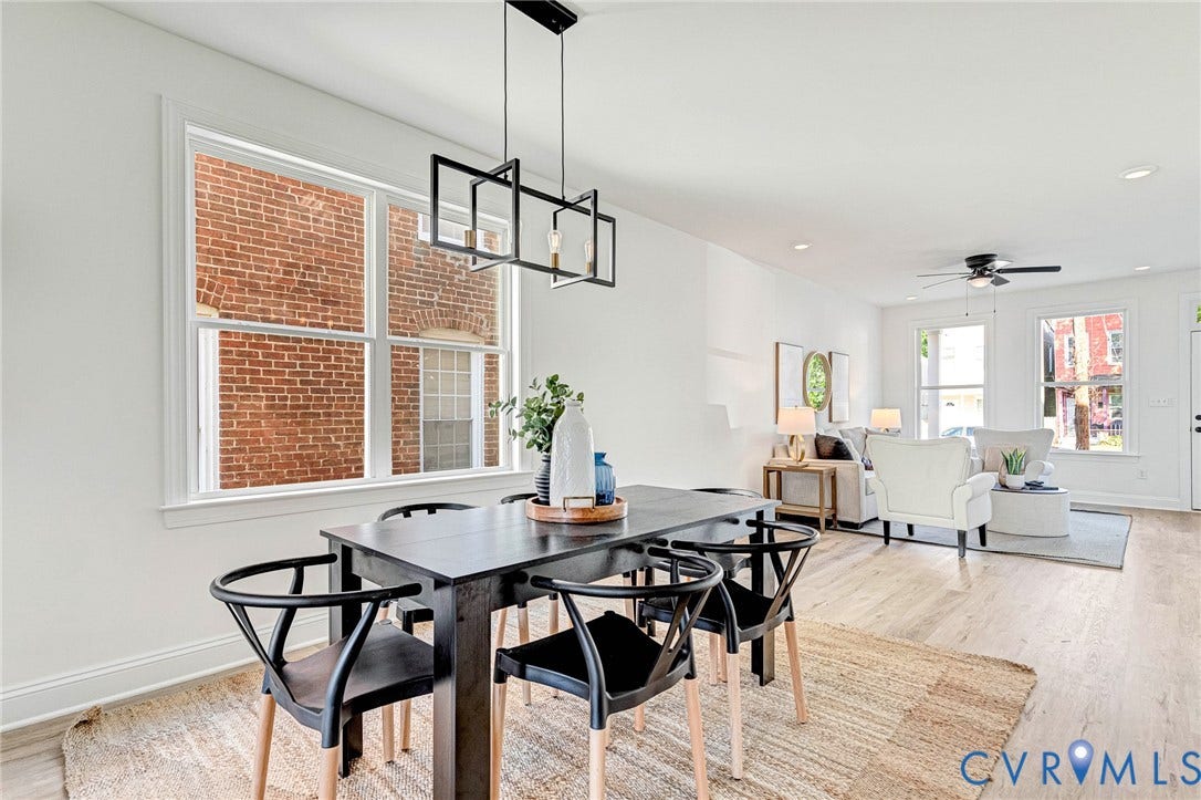 Open-concept living area with light wood-finish flooring, recessed lighting, and a modern rectangular chandelier