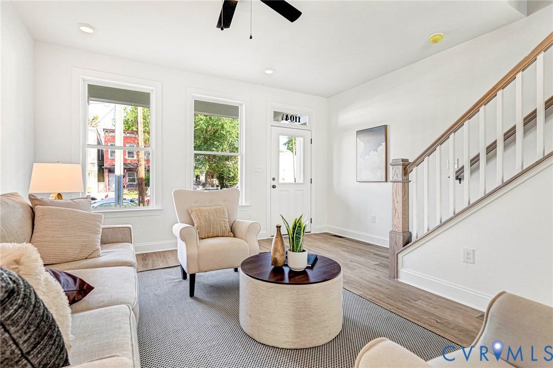 Recessed lighting illuminates the wood-finish flooring and white walls